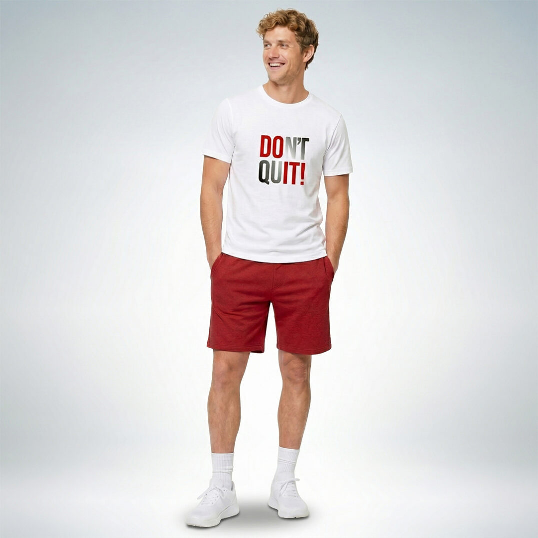 Männliches Model trägt weißes T-Shirt mit „Don’t quit!“ Print und rote Shorts im sportlich-lässigen Look – Sinnstoff