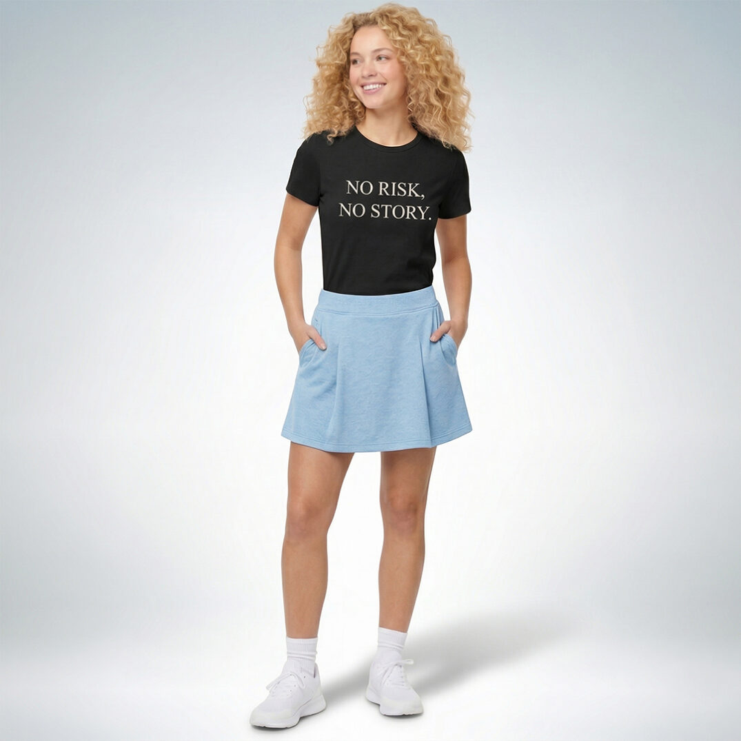 Weibliches Model trägt schwarzes T-Shirt mit „No risk, no story“ Print und hellblauen Rock im cleanen Casual-Look – Sinnstoff
