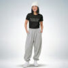 Weibliches Model mit weißer Mütze trägt schwarzes T-Shirt mit „Positive mind. Positive life.“ Print und graue Jogginghose – Sinnstoff