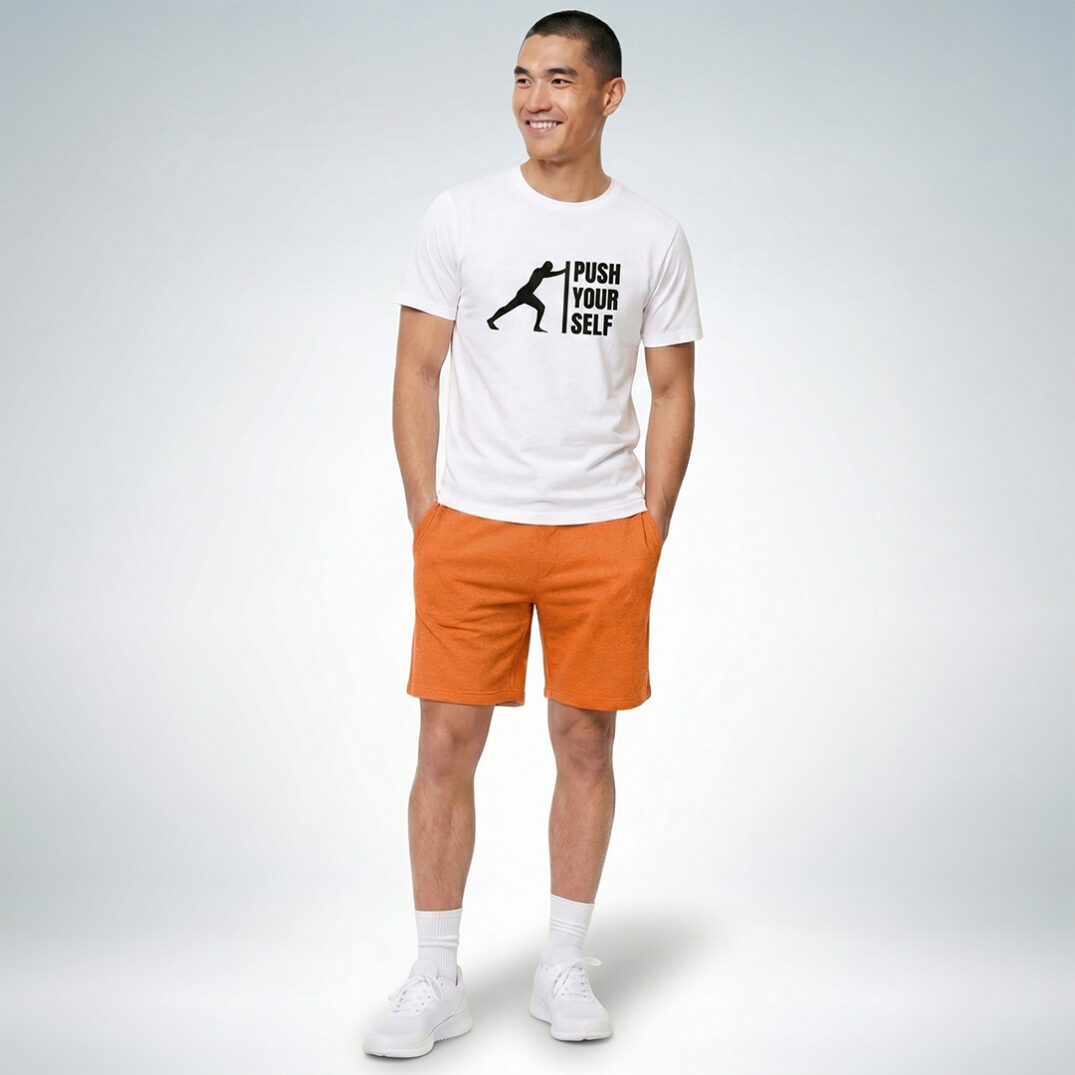 Männliches Model trägt weißes T-Shirt mit „Push yourself“ Print und orange Shorts im sportlich-lässigen Look – Sinnstoff