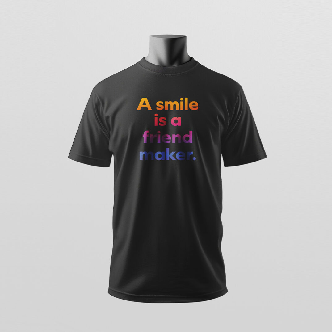 Ein schwarzes T-Shirt mit farbiger Aufschrift „A smile is a friend maker.“ wird modern präsentiert – Sinnstoff.