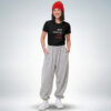 Weibliches Model mit roter Mütze trägt schwarzes T-Shirt mit „Stop wishing. Start doing.“ Print und graue Jogginghose – Sinnstoff