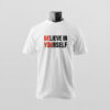Ein weißes T-Shirt mit kontrastreicher Aufschrift „BELIEVE IN YOURSELF“ in Rot und Weiß wird schlicht vor neutralem Hintergrund präsentiert – Sinnstoff