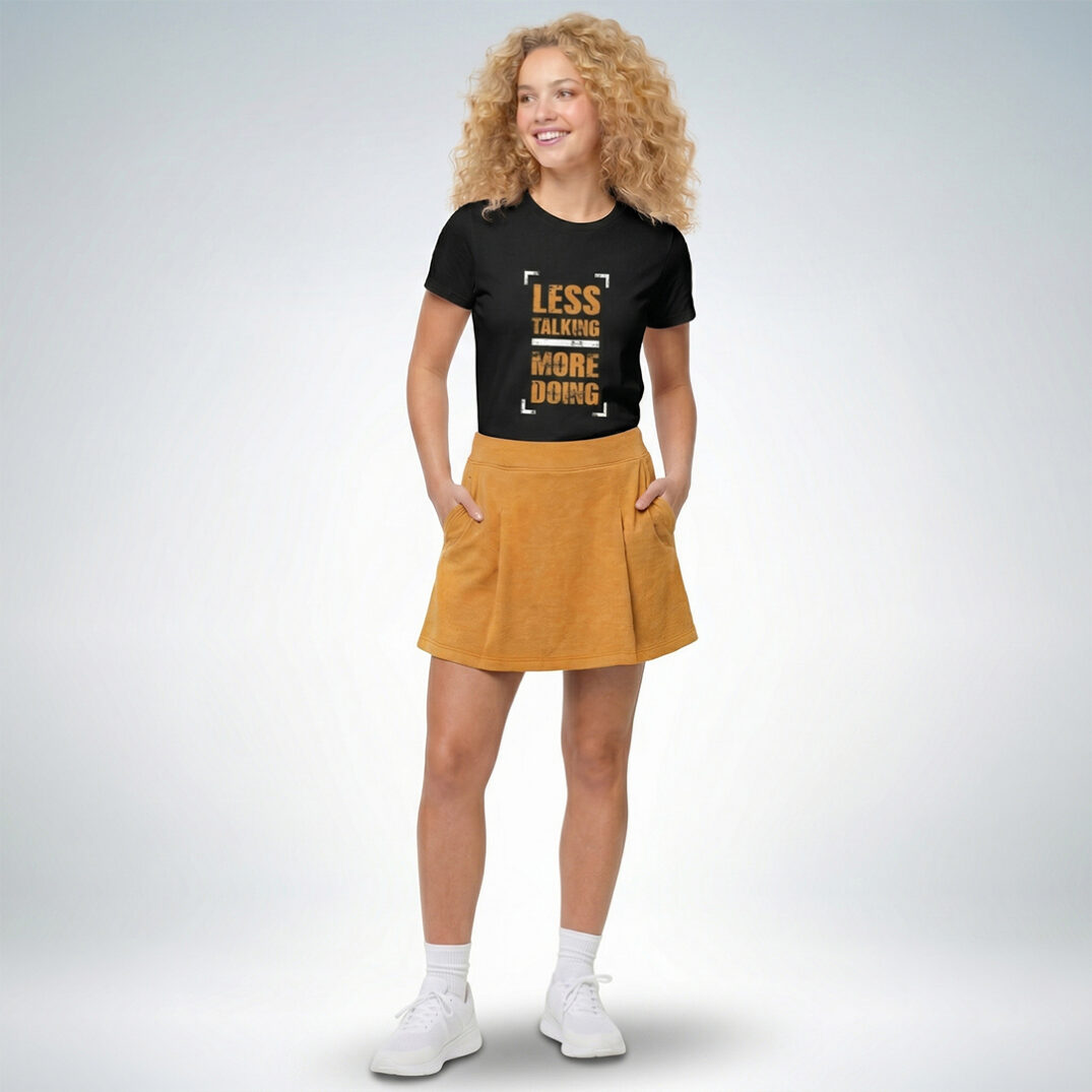 Ein weibliches Modell präsentiert ein schwarzes T-Shirt mit der Aufschrift „Less talking more doing“ – Sinnstoff.