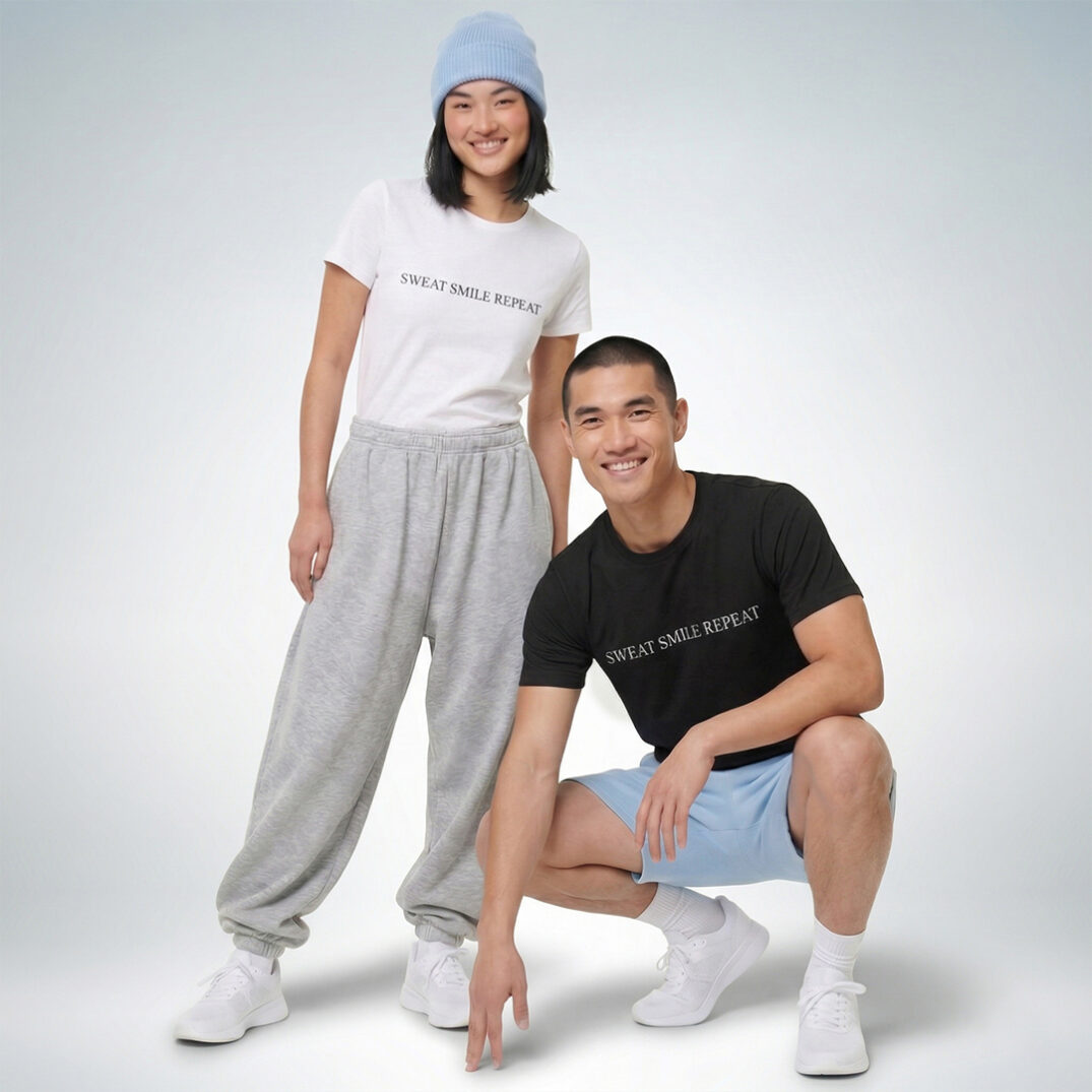 Zwei Models präsentieren schwarze und weiße T-Shirts mit der Aufschrift „Sweat Smile Repeat“ – Sinnstoff.