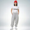 Weibliches Model mit roter Mütze trägt weißes T-Shirt mit „Let’s be better humans“ Print und graue Jogginghose – Sinnstoff